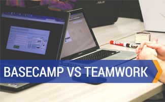Team collaborating on computers in conference room