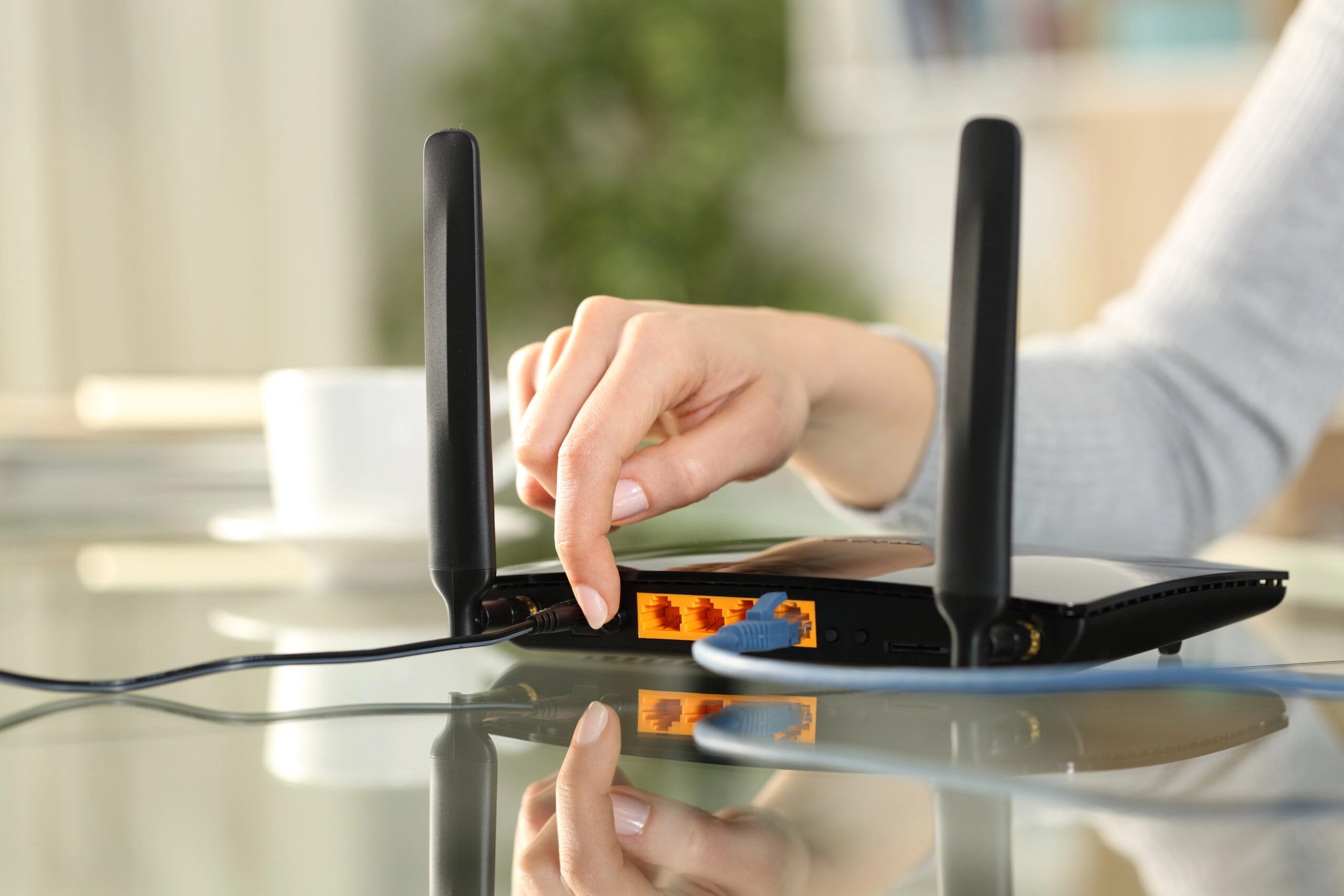 Close up of a woman hand reseting or turning on modem at home