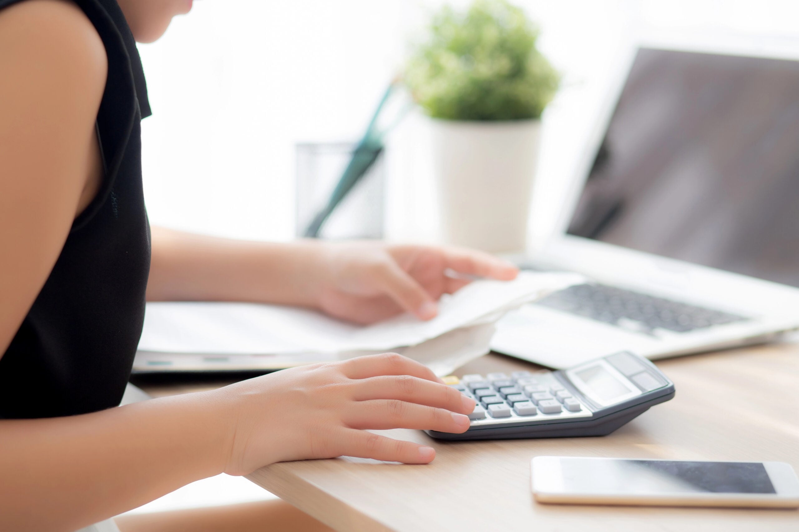 closeup hand woman calculating expenses household and writing notebook on desk, girl checking bill and stress and note, female worry debt and tax, finance and business concept.