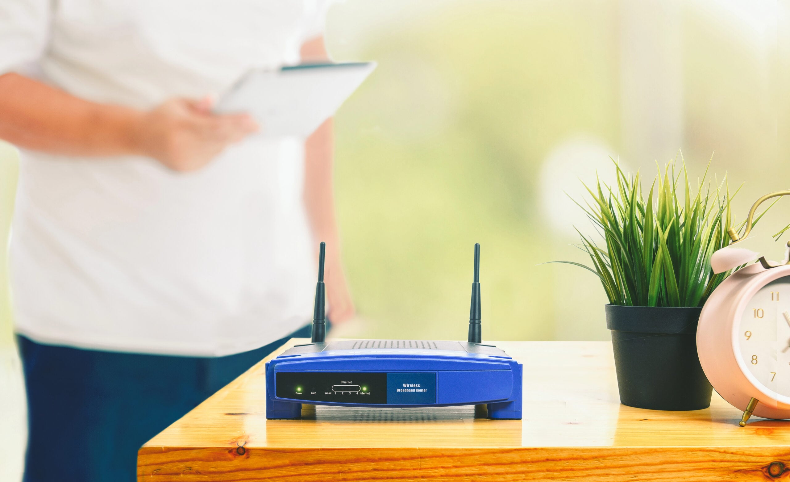 closeup of a wireless router and a man using smartphone on living room at home ofiice
