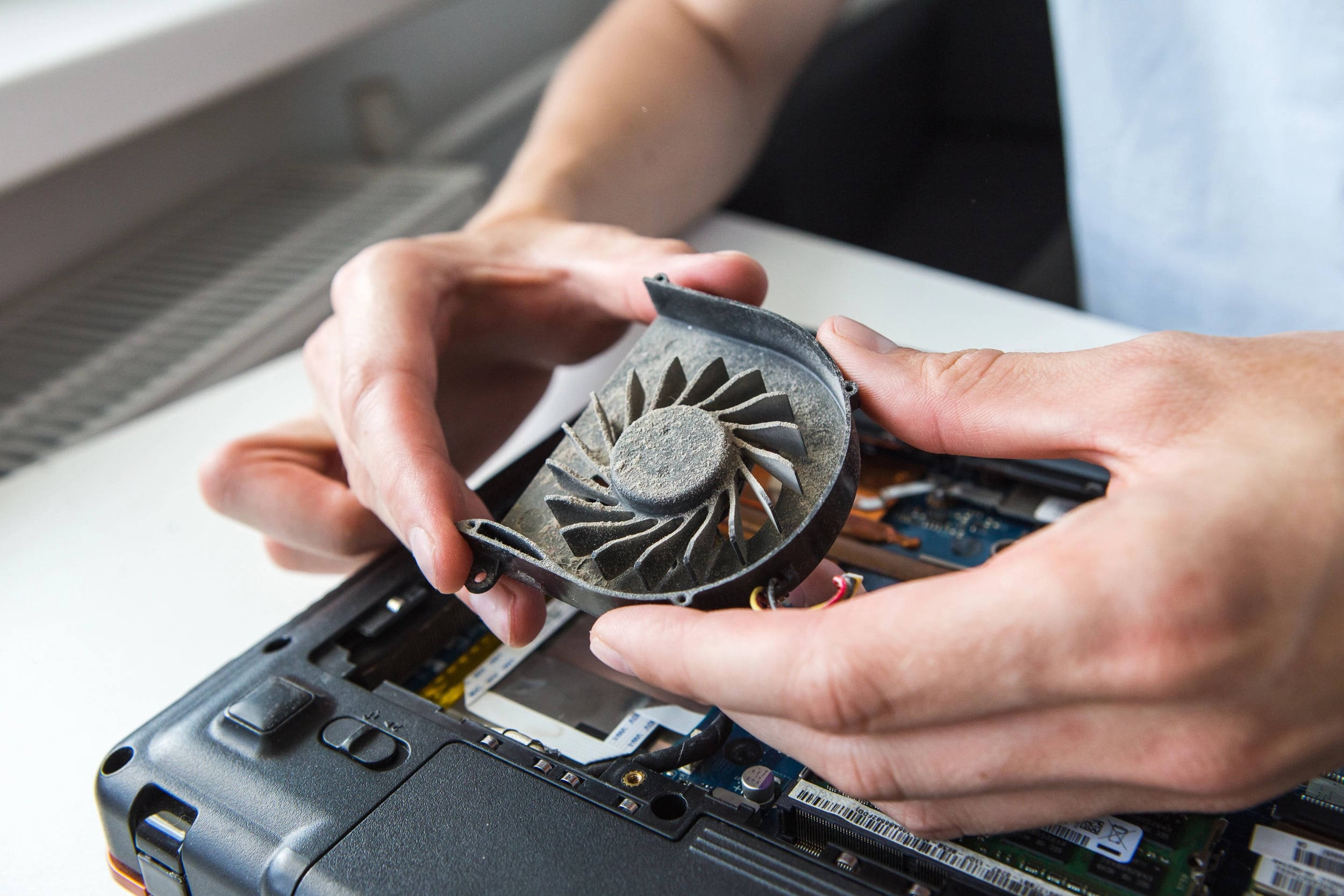 man holding dirty laptop fan