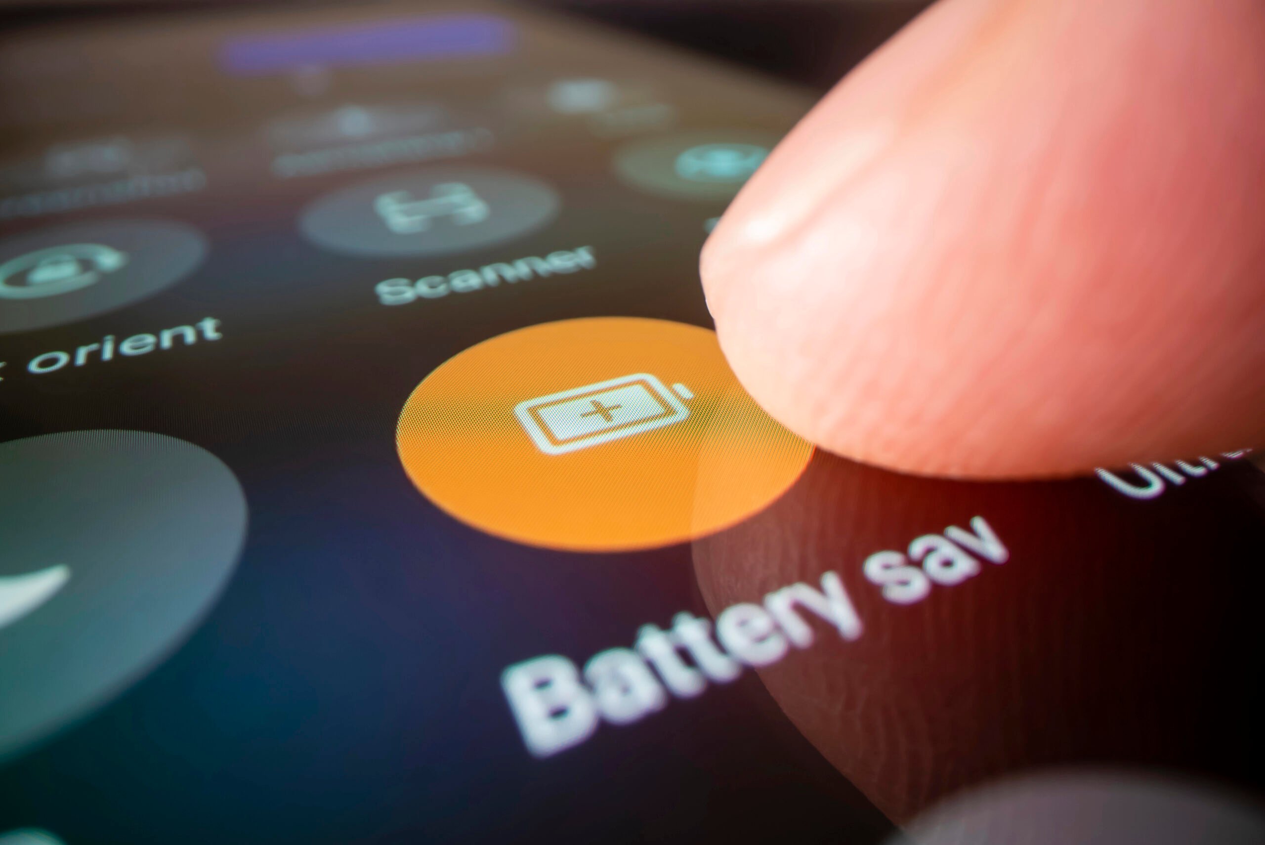 Close up of a finger on the battery save icon on a smarthphone.