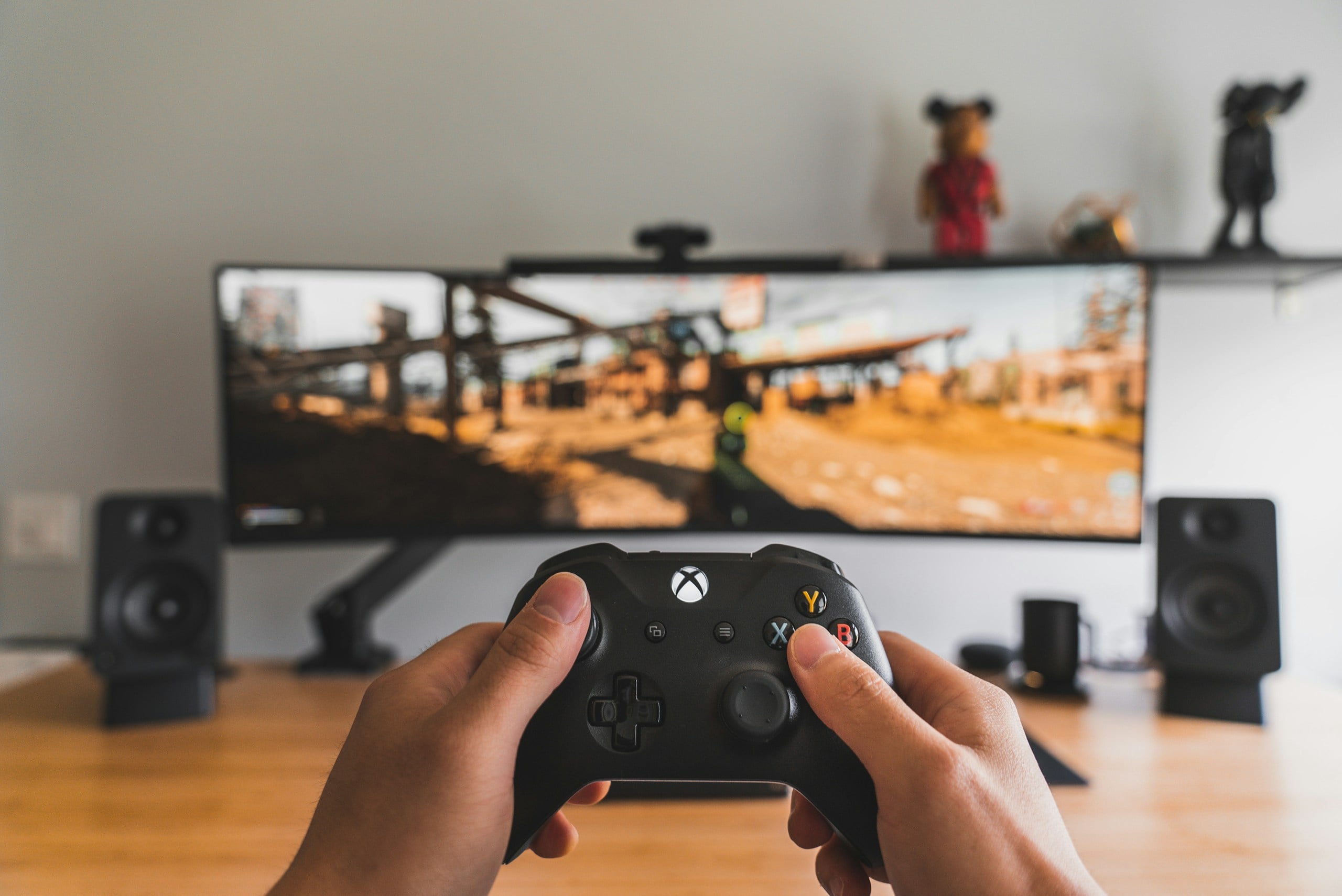 Person holding a black game controller playing an online game.