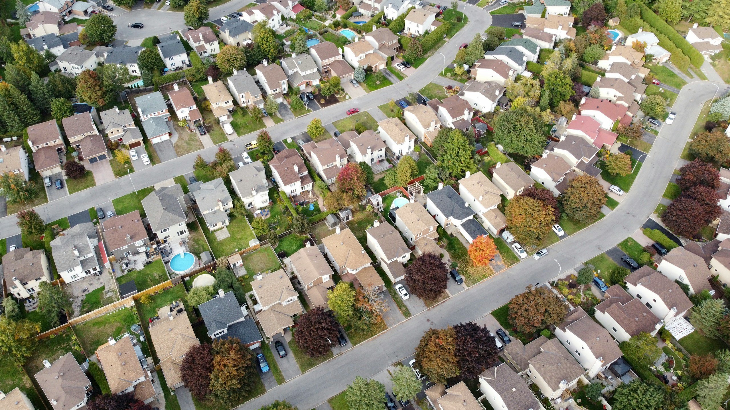 Suburban landscape with houses, roads, trees.
