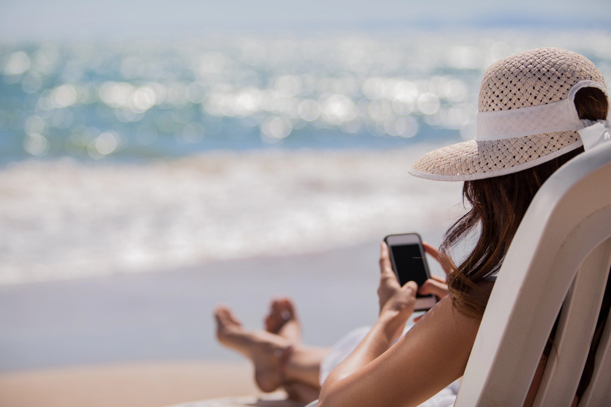 Young woman with mobile phone on a beach